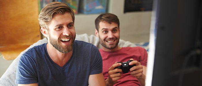 Dois homens em frente a uma televisão, jogando videogame